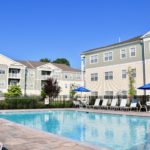 Resort style swimming pool with entertainment pool deck at Broadleaf Boulevard apartments.